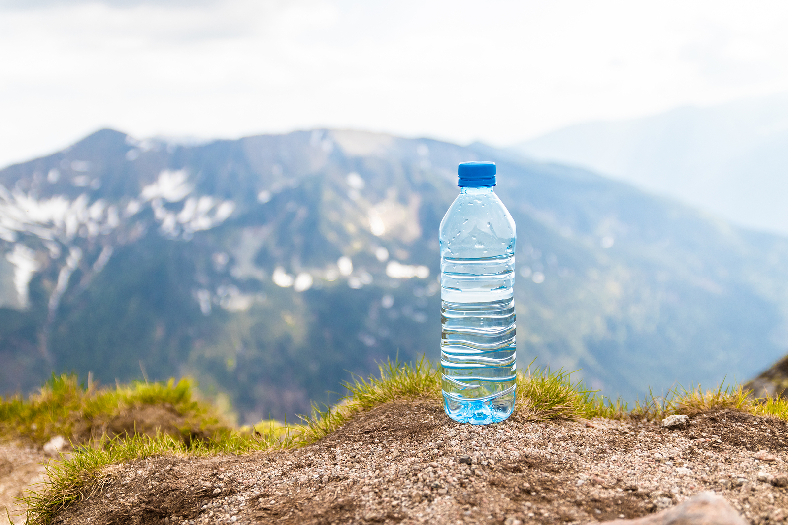 Water in plastic bottles on the stone against the background of a picturesque view of mountains.