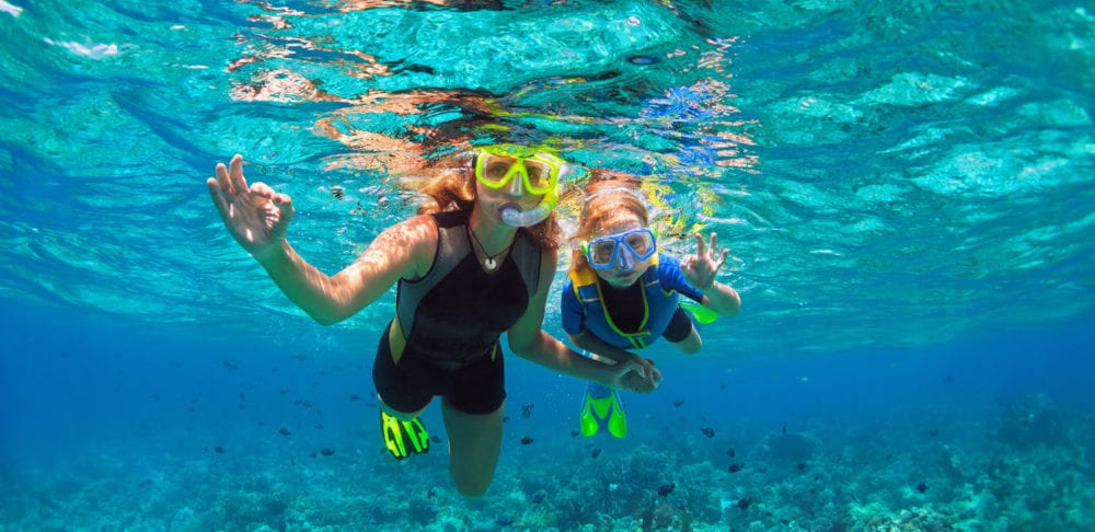 Family snorkeling in coral reef