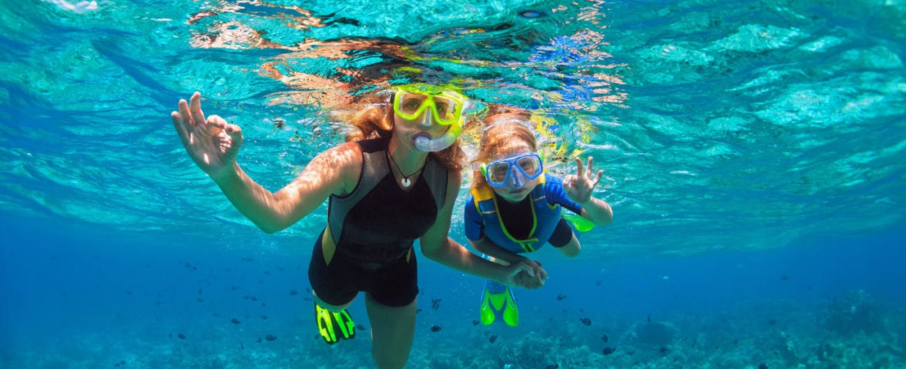 Family snorkeling in coral reef