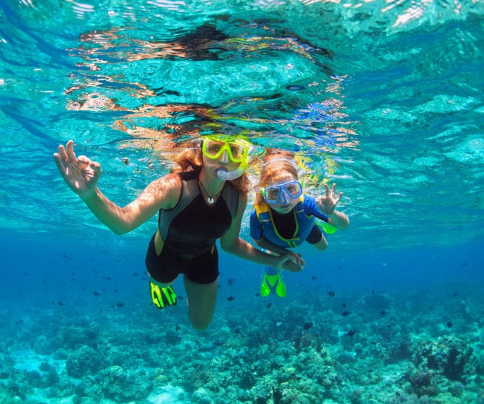 Family snorkeling in coral reef