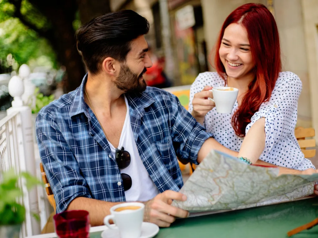 Smiling tourist couple in cafe bar.